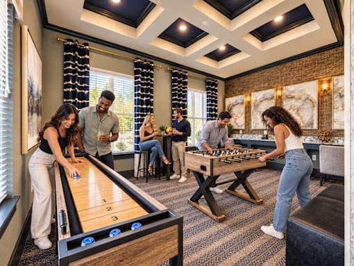 A group of people playing pool in a room with a high ceiling.