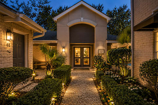 A house with a lit pathway leading to the front door.