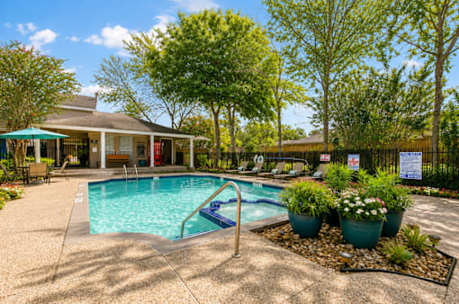 A pool with a slide and a house in the background.