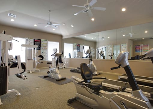 a gym with treadmills and other exercise equipment at Addison Park Apartments in Arlington, TX.