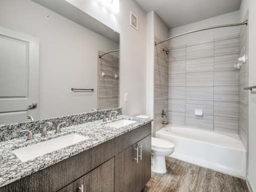 A bathroom with a marble countertop and a white toilet.