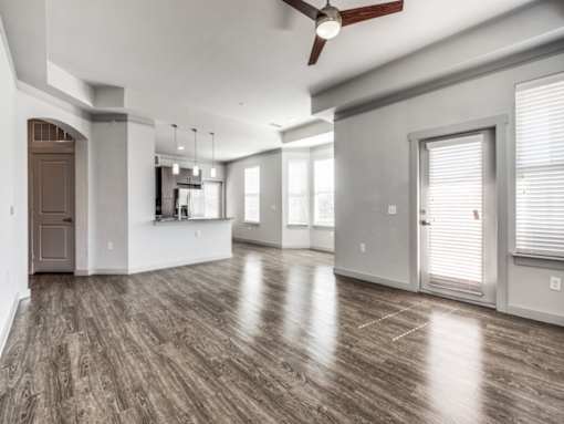 A spacious room with wood flooring and a ceiling fan.