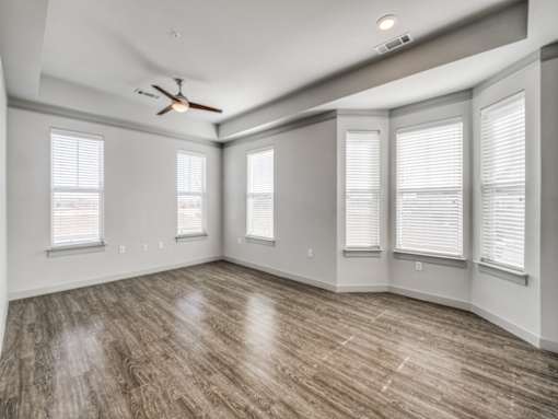 A room with wooden flooring and a ceiling fan.