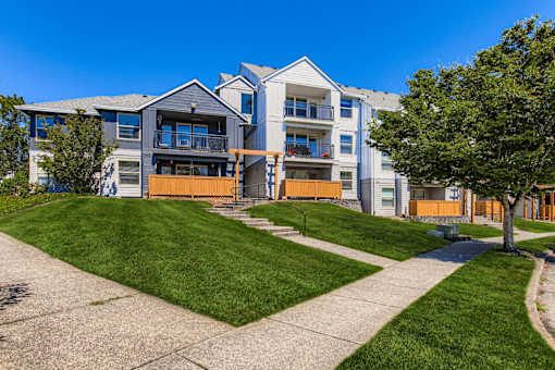 A modern apartment building with a green lawn in front.