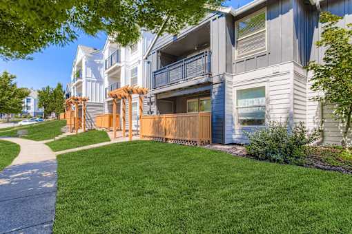 A modern apartment building with a well-maintained lawn in front.