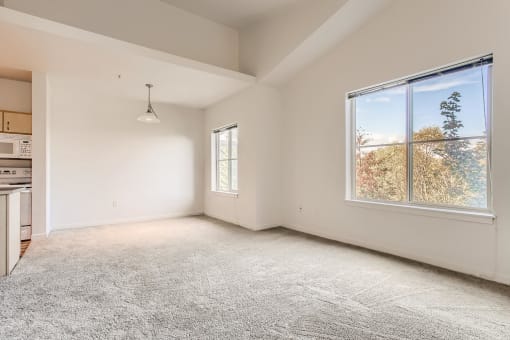 Fairview Apartments for Rent - Spacious Living Room with Carpet, Two Large Windows and Dining Area.