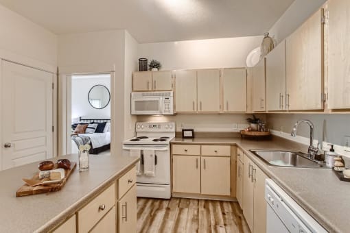 Fairview OR Apartments for Rent - Lodges at Lake Salish - Kitchen with Light Wood Cabinets. White Appliances, and an Island