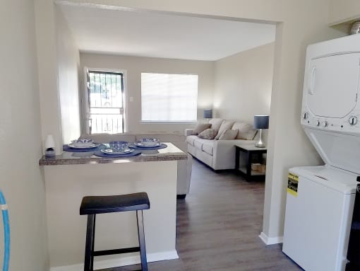 a small living room with a white couch and a white washer and dryer