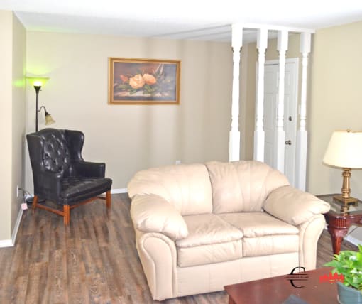 a living room with a white couch and a black chair