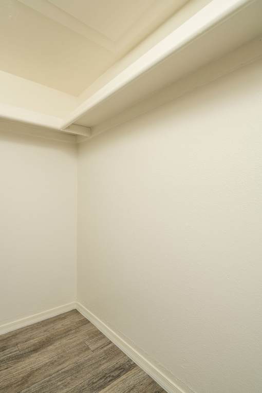 A corner of a room with a wooden floor.