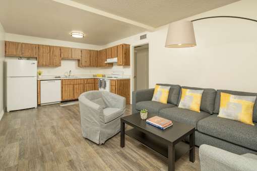 A living room with a grey couch, a grey armchair, and a coffee table.