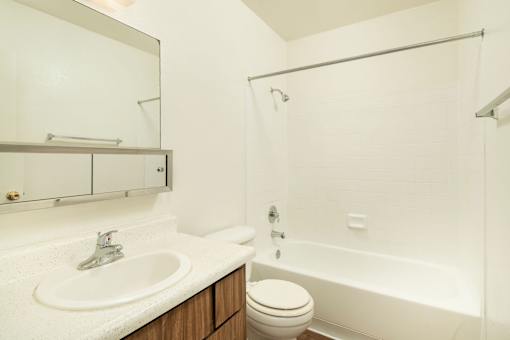 A white bathroom with a sink, toilet, and bathtub.