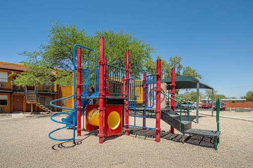 A playground with a red and blue slide and a yellow and red tunnel.