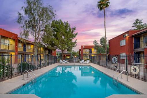 A swimming pool surrounded by a fence and buildings.