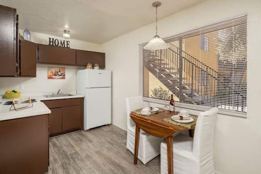 A kitchen with brown cabinets and a white refrigerator.