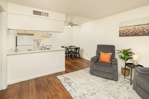 A kitchen with a grey chair and a white fridge.