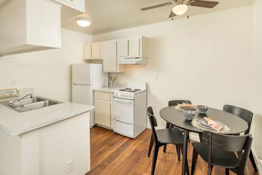A kitchen with a table and chairs.