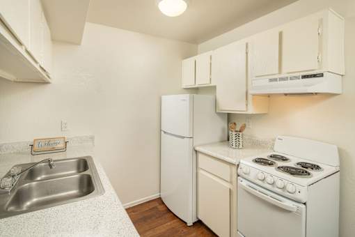 A small kitchen with a white stove and a white refrigerator.