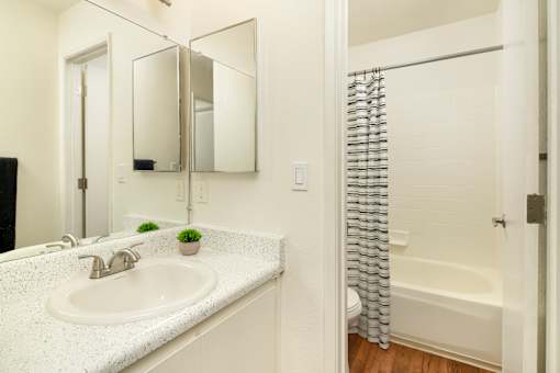 A white bathroom with a sink and a bathtub.
