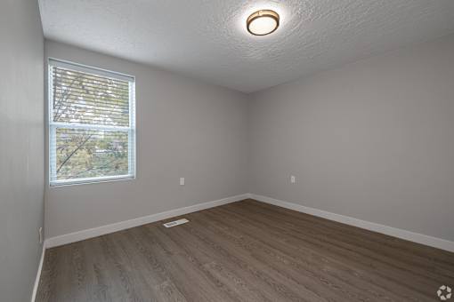 A room with a window and wooden flooring.