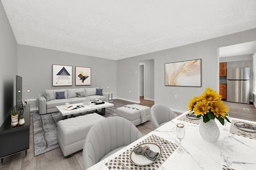 A modern living room with a grey sofa set and a white dining table set with a vase of sunflowers.