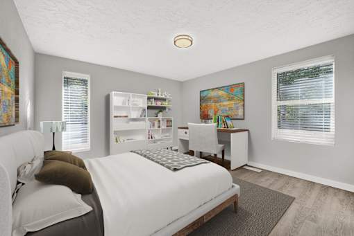 A bedroom with a bed, desk, and a painting on the wall.