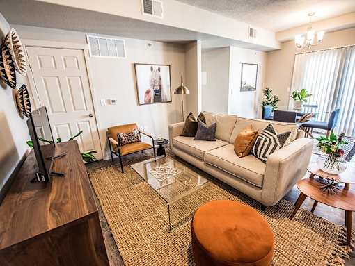 A living room with a couch, a coffee table, and a television.