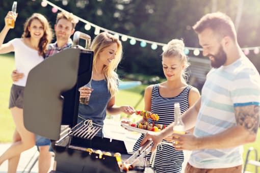 people grilling food at a backyard barbecue
