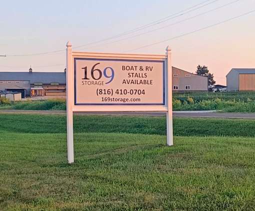 A sign for 169 Boat & RV Storage is displayed in a grassy area.