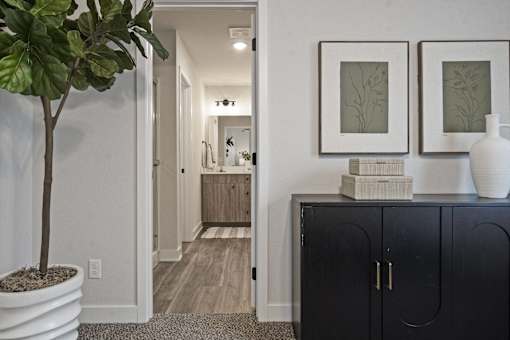 A black cabinet with a white vase on top of it.