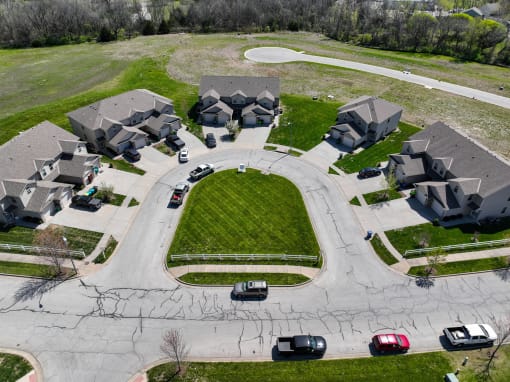 an aerial view of a suburban neighborhood with cars parked in front of houses