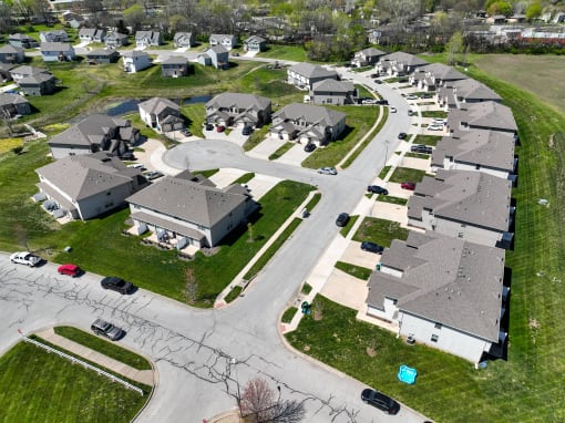 an aerial view of a neighborhood of houses with cars parked