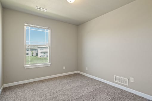 an empty room with carpet and a window