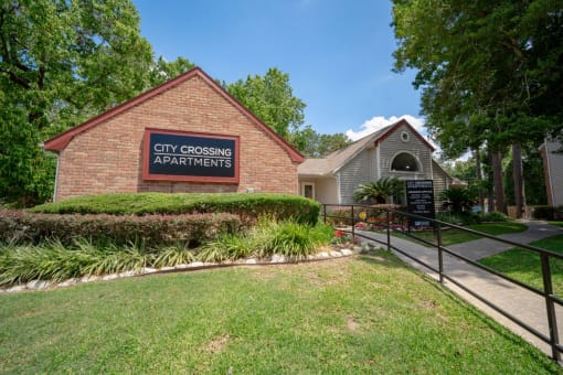a brick building with a sign that reads city crossing apartments