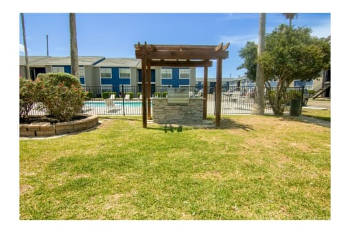 a backyard with a gazebo and a pool in the background
