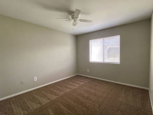 a bedroom with a ceiling fan and a window