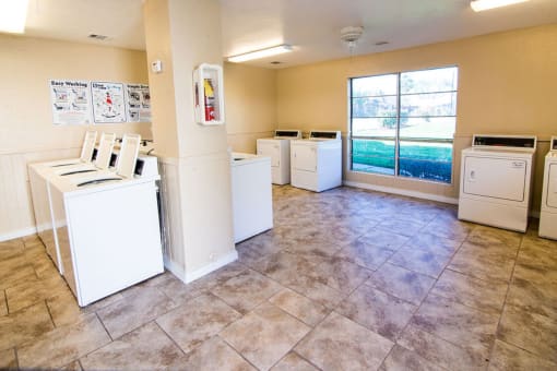 an empty laundry room with washers and dryers