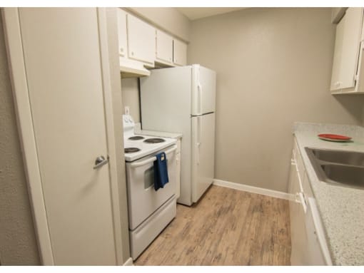 a kitchen with a white refrigerator freezer next to a stove top oven