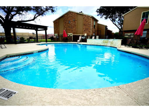a swimming pool with a brick building in the background