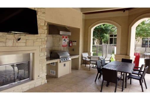 a patio with a fireplace and a table and chairs