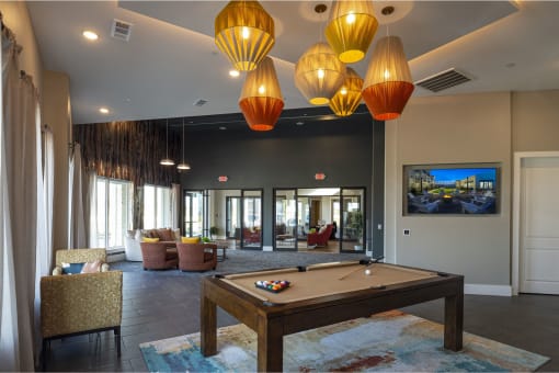 a resident clubhouse with a pool table and a flat screen tv