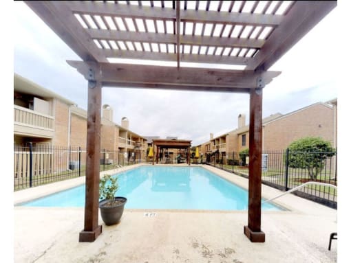 a swimming pool with a pergola in front of it