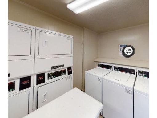 a washer and dryer in a laundry room with a clock on the wall
