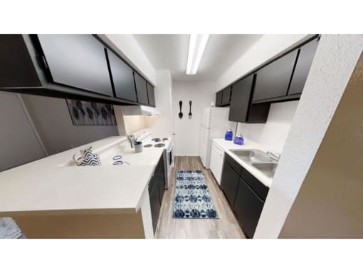 a kitchen with black cabinets and a white counter top