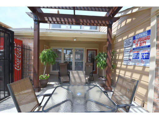 a patio with a table and chairs in front of a building