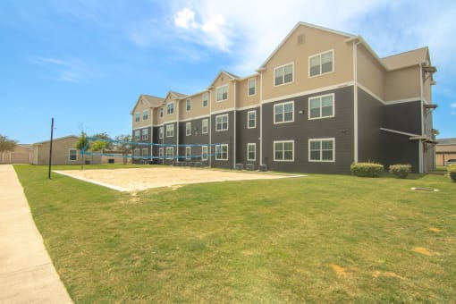 a large apartment building with a grassy area in front of it