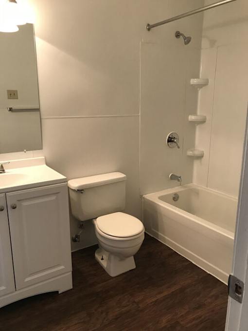 A white toilet sits next to a white sink in a small bathroom.