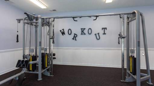 A workout room with a white wall and a black floor.