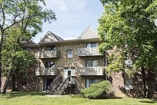 A large house with a balcony and a staircase leading to the entrance.