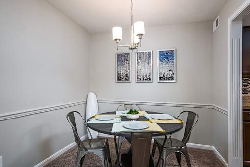 A dining room with a table set for two.